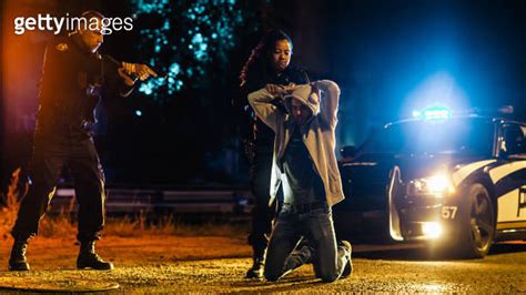 Black Female Police Officers Handcuffing A Compliant Suspect While Her