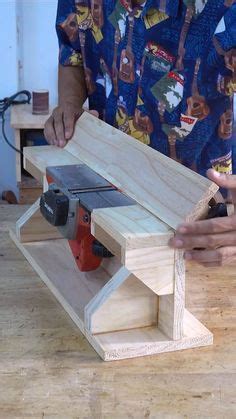 A Man Is Working On A Workbench With A Planer And Drill Bit