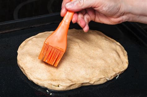 Premium Photo Oiling The Crust Of Raw Pie By Silicone Brush