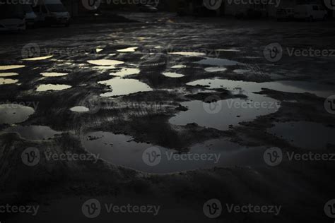 Large puddle in dark. Reflection of light in puddle. Bad road in Russia ...