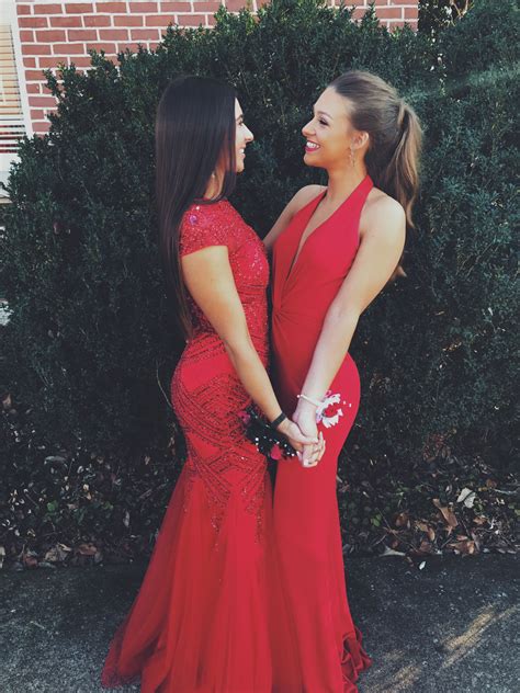 Two Women In Red Dresses Standing Next To Each Other