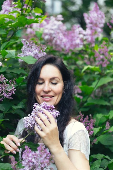 Portrait Of An Attractive Woman Surrounded By Lilac Bushes Spring And