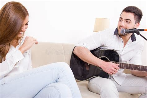 Hombre Hermoso Que Toca La Guitarra A La Muchacha Imagen De Archivo