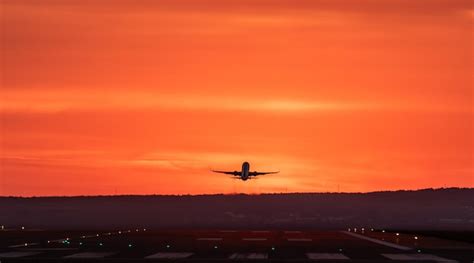 Premium Photo Airplane Flying Against Orange Sky