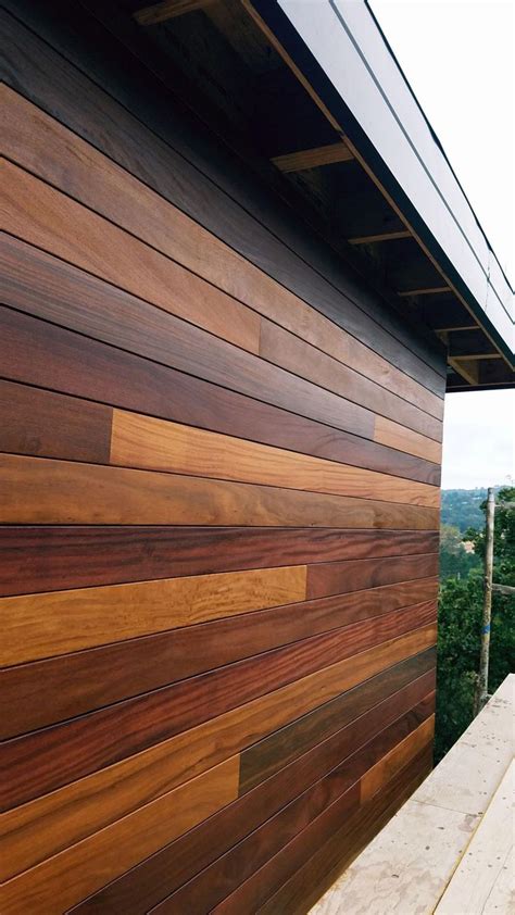 The Side Of A Building With Wood Siding On It S Sides And Trees In The