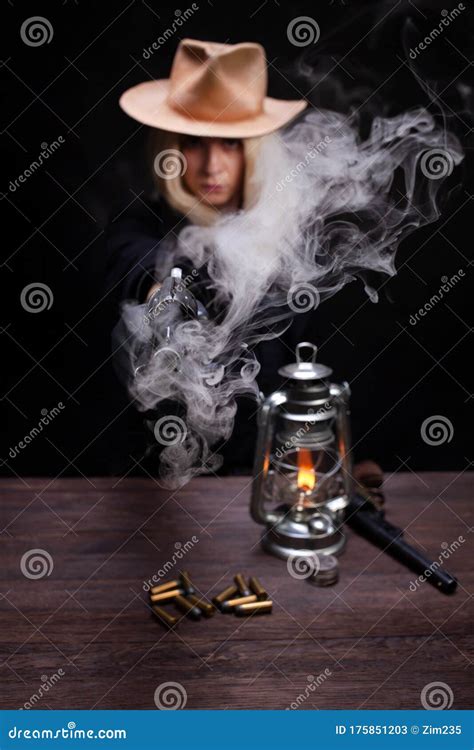 Wild West Blonde Girl Shooting From Revolver Gun At The Table With