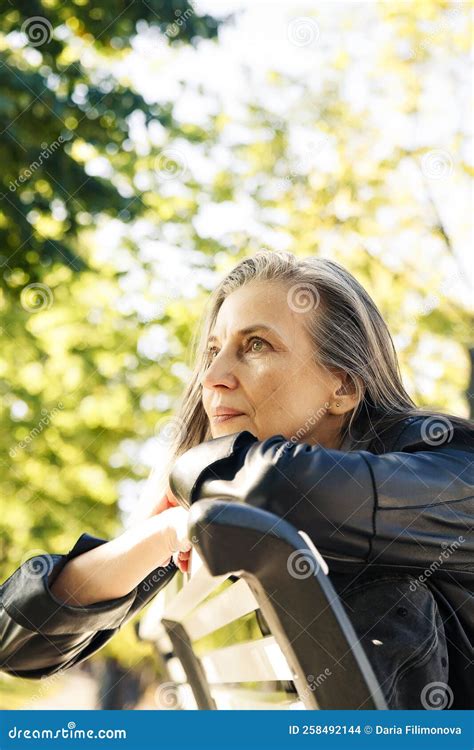 Portrait Of Beautiful Gray Haired Elderly Woman In Park On Bench Stock