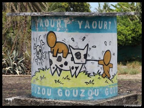 A Painted Trash Can Sitting On The Side Of A Road In Front Of Some Trees