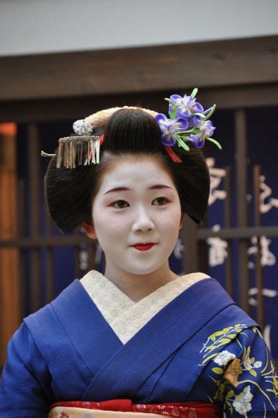 A Geisha Woman In Traditional Japanese Dress And Hair Comb With Flowers