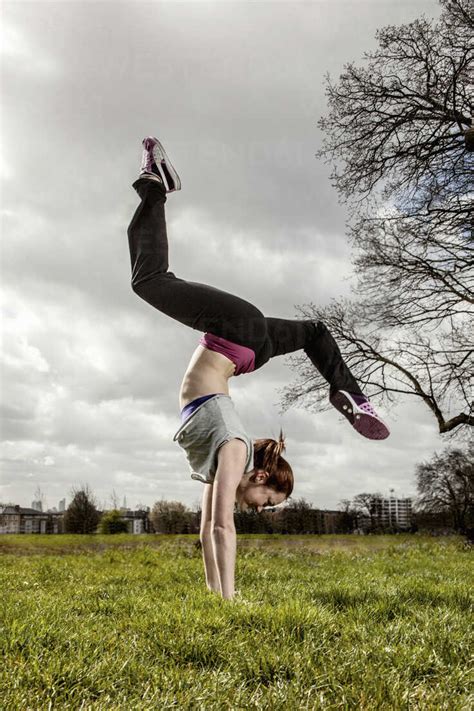 Woman Doing Handstand With Legs Apart Stock Photo