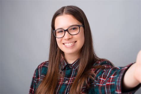 Premium Photo Photo Of Cheerful Young Woman With Eyeglasses And Taking Selfie