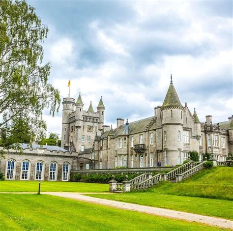 A Large Castle Like Building Sitting On Top Of A Lush Green Field