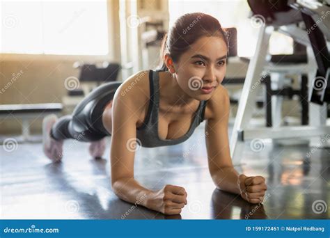 Beautiful Asian Fitness Young Woman In Sportswear Doing Plank In Gym