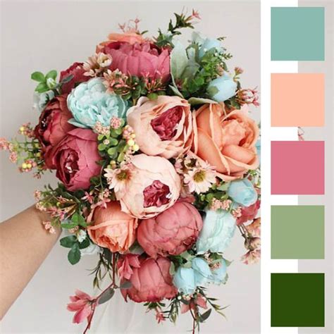 A Bouquet Of Flowers That Are Shades Of Peach Coral Ocean Blue And