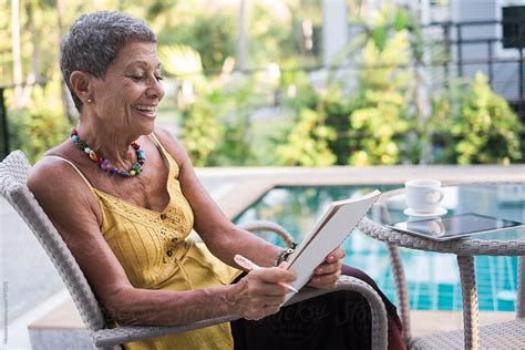 Senior Woman Reading And Smiling By Stocksy Contributor Mosuno