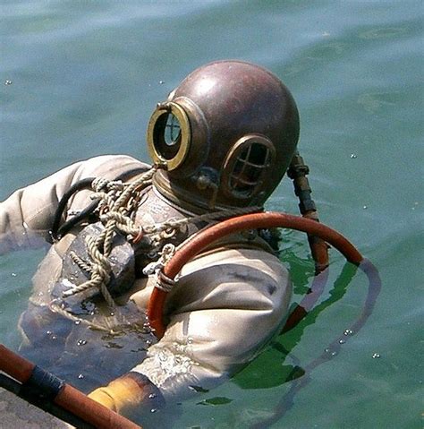 A Man Wearing A Diving Suit And Helmet In The Water