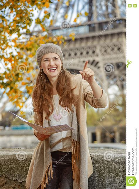 Mulher Do Turista Na Terraplenagem Em Paris Que Guarda O Mapa E Apontar