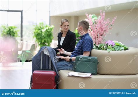 Man And Woman In Business Suits Talking And Waiting For Plane At