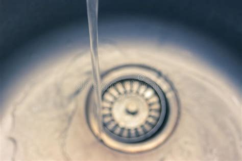 The Stream Of Water Flowing From The Tap In The Sink The Concept Of