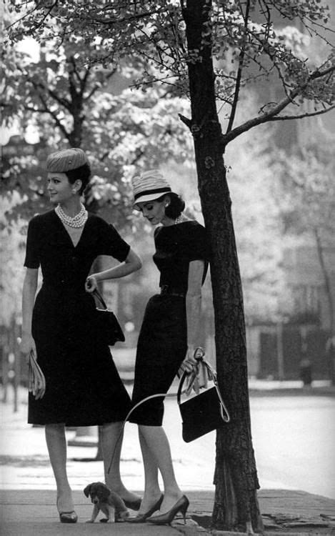 Two Women Standing Next To Each Other Near A Tree