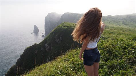 A Girl Standing On The Edge Of A Cliff