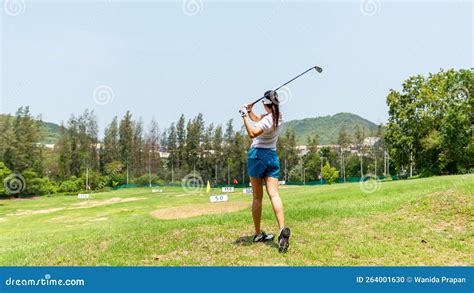 Asian Golfer Woman Swing Golf Ball Practice At Golf Driving Range For