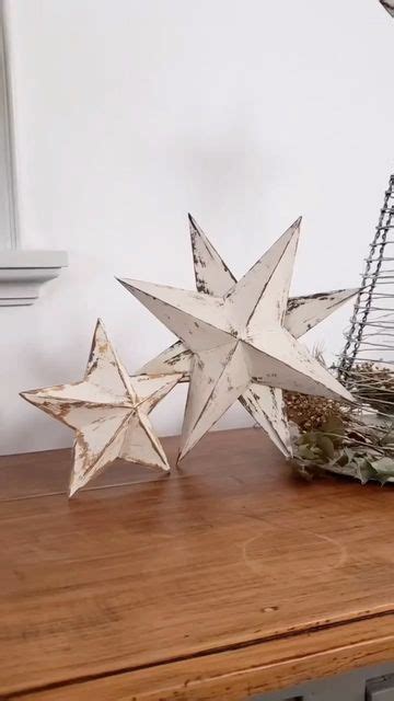 Two White Stars Sitting On Top Of A Wooden Table Next To A Wire Basket