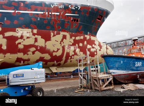 Repairing And Painting Hull Of A Ship In Dry Dock In Reykjavik Harbour