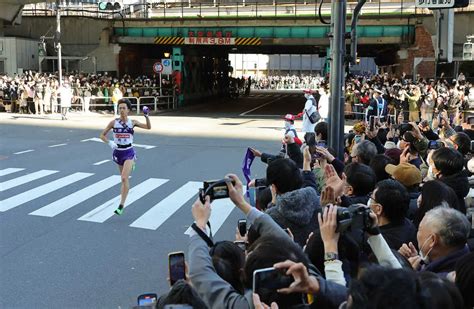 ＜第99回箱根駅伝・復路大手町ゴール＞ 沿道に詰めかけた大勢の観客がカメラを向ける中、ガッツポーズでゴールに向かう駒大10区・青柿 （撮影