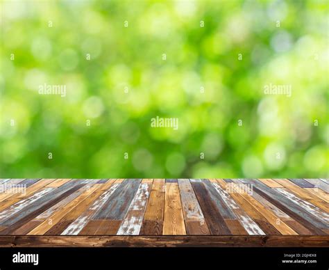 Empty Wood Plank Table Top With Blur Green Tree In Park Bokeh Light