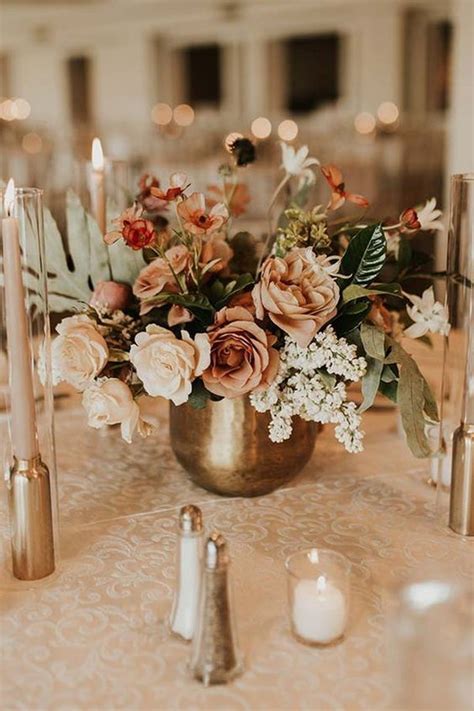 A Delicate Fall Wedding Centerpiece Of A Brass Vase With Neutral And