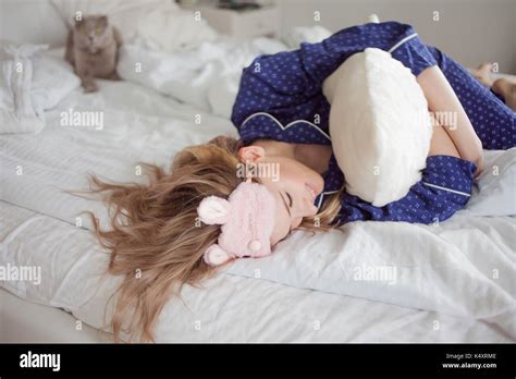 Cute blonde se réveilla dans son lit le confort d accueil d une chambre et le chat Photo Stock