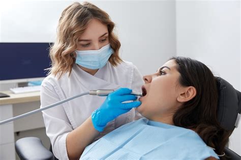 Dentista Perfurando Dente De Paciente Do Sexo Feminino Na Cadeira