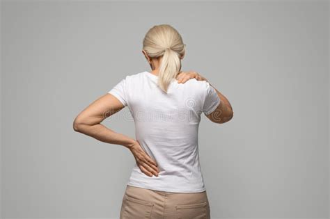 Unrecognizable Mature Blonde Woman Suffering Neck And Back Pain Stock