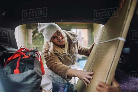 Smiling Mature Woman Loading Cardboard In Car Trunk Royalty Free