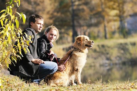 Familia Joven Con El Perro Foto De Archivo Imagen De Bosque