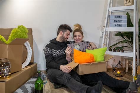 Young Couple Carrying Big Cardboard Box At New Home Moving House Stock