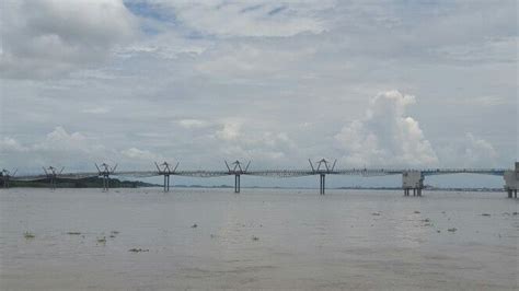 A Large Bridge Spanning Over A Body Of Water With Clouds In The Sky