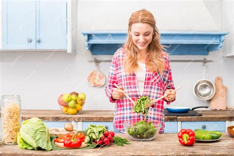 Free Photo Portrait Of A Smiling Young Woman Holding Fresh Spinach