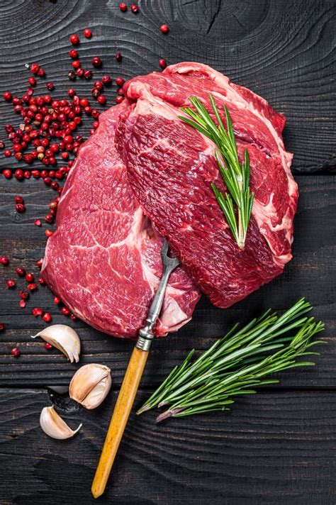 Raw Fresh Chuck Roll Steak With Herbs And Salt On A Cutting Board Gray