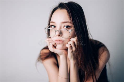 Retrato De Una Mujer Seria Hermosa Con Los Vidrios En El Fondo Blanco