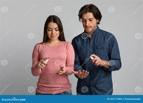 Precautions during Coronavirus Outbreak. Young Couple Applying Disinfectant Spray on Hands Stock ...