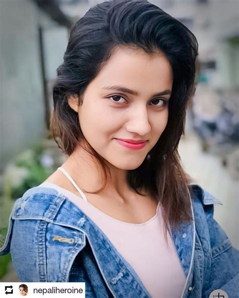 A Woman With Long Black Hair Wearing A Jean Jacket And White Shirt