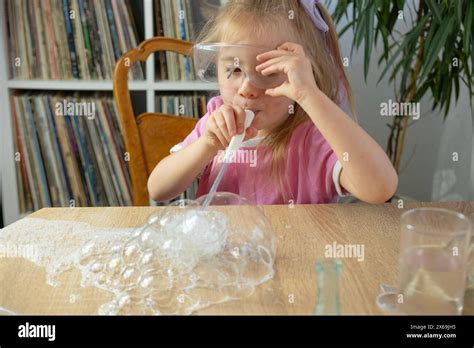 Little Girl Blows Bubbles Through Plastic Straw Made Of Soap Foam Kids