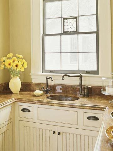 A White Kitchen With Yellow Flowers In The Window