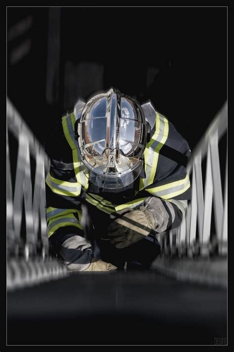 A Fireman In Full Gear Crouching Down