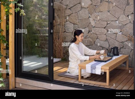 Elegant Mature Chinese Woman Drinking Tea In Tea Room Stock Photo Alamy