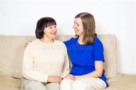 Young Caregiver Helping Senior Woman At Home Caring Nurse Hugging Her