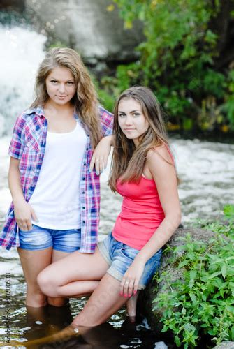 Two Teen Girls And Summer Outdoors Near Waterfall Buy This Stock