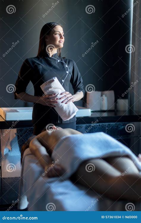 Masseur Holding Towel Next To The Massage Table On Which A Beaut Stock